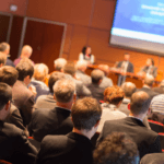 A crowd engaged in a panel of experts speaking