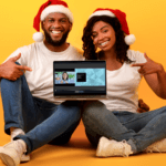 A couple wearing matching Santa hats sits with a laptop propped up on their knee, pointing to what's on the screen, which is the new Browser Capture Studio.