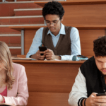 A group of students on their phones in a university lecture.