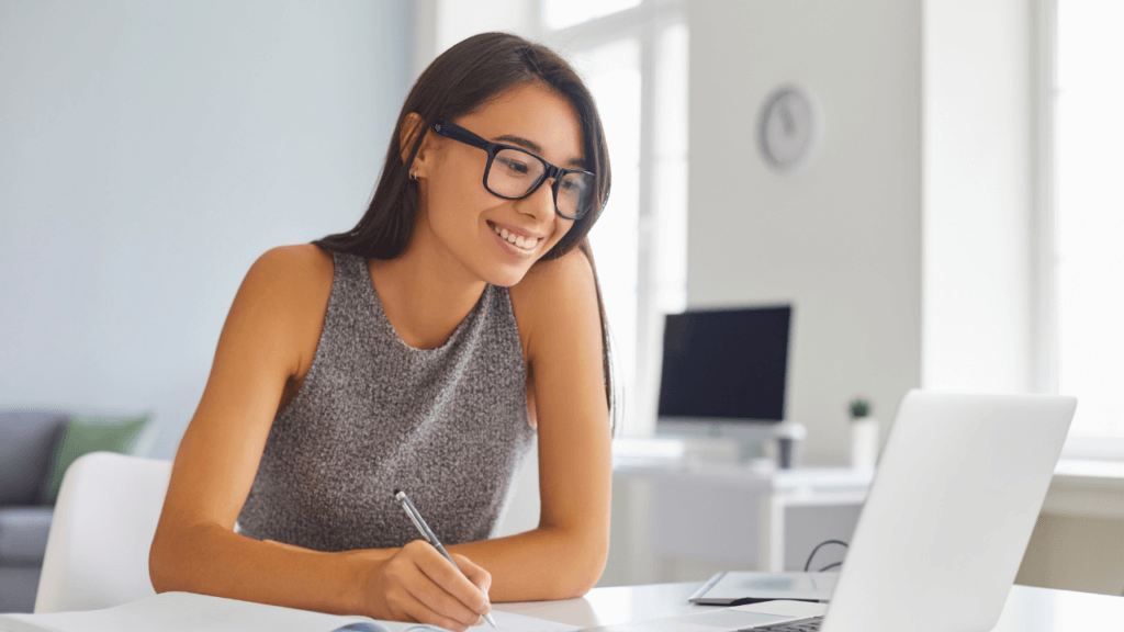 A woman in glasses looking at a screen