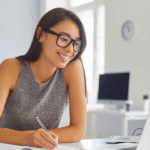 A woman in glasses looking at a screen