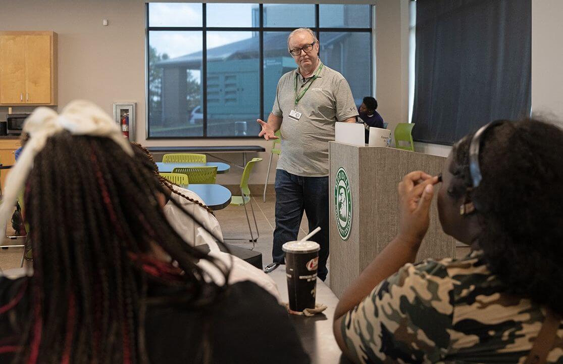 An instructor speaking to a group of MCC students.